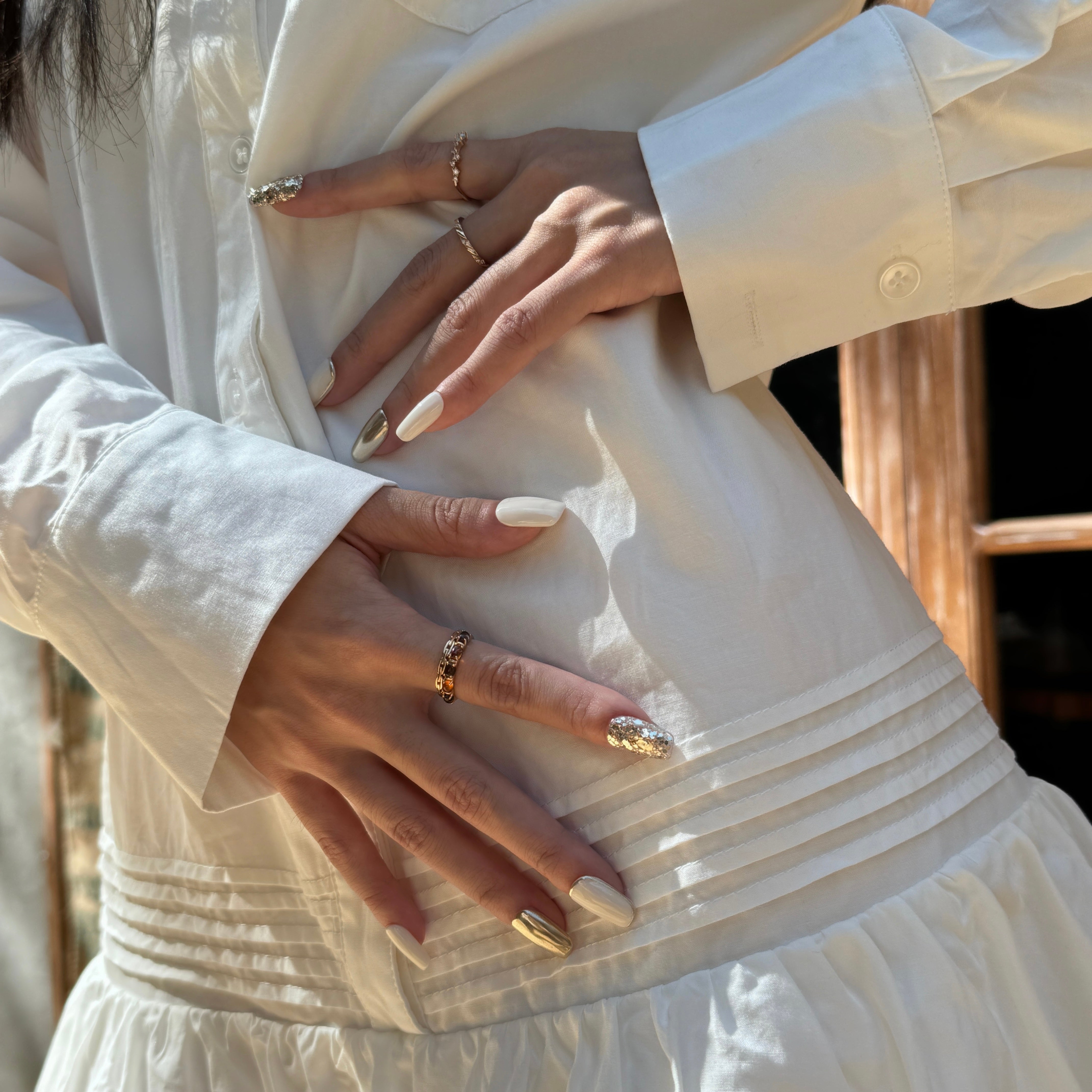 Fincloset Ivory Luxe handmade square-shaped press-on nails in ivory and gold with sparkling gold glitter accents.