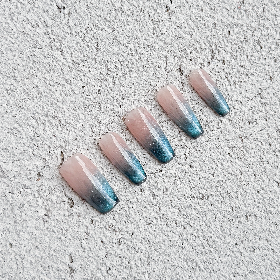 Handmade long coffin-shaped French press-on nails with blue gradient cat-eye effect and subtle sparkles, offering a minimalist and elegant style.