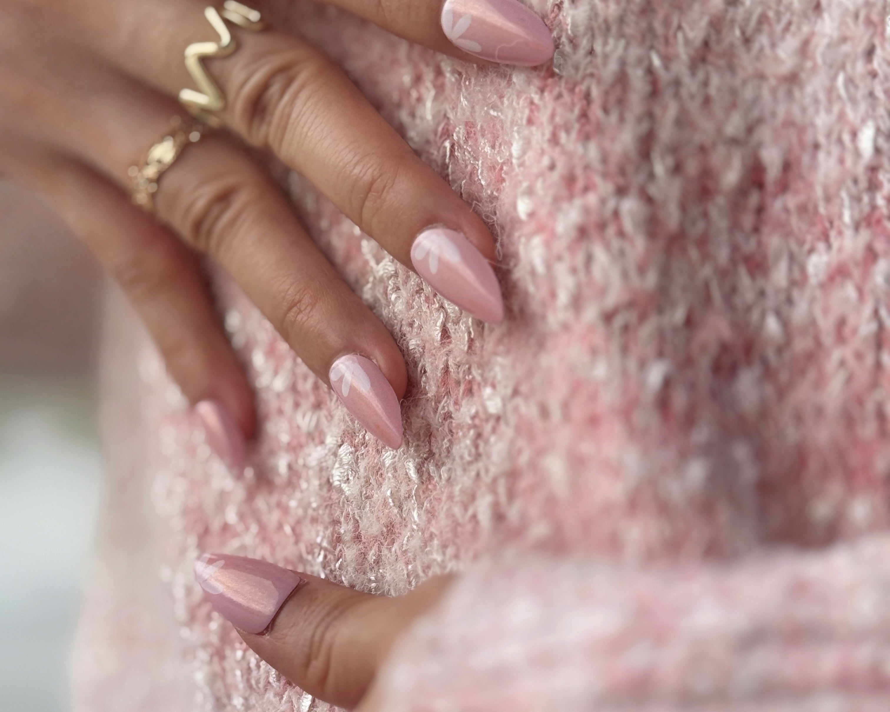 Fincloset soft pink natural almond-shaped press-on nails with yellow shimmer, fine glitter, and dainty white floral designs, creating a fresh, feminine, and radiant spring-inspired manicure.