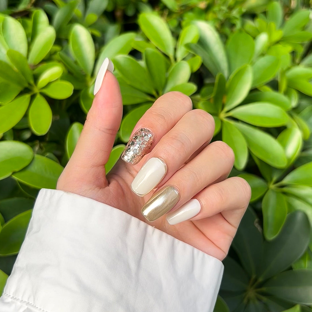 Ivory Luxe handmade square-shaped press-on nails in ivory and gold with sparkling gold glitter accents