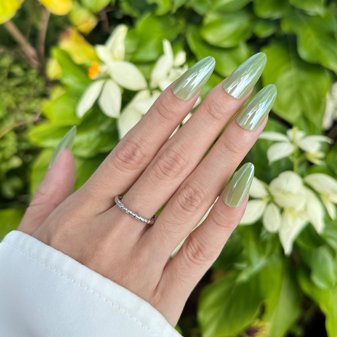 Satin glossy almond-shaped press-on nails in apple green for a fresh, trendy vibe.