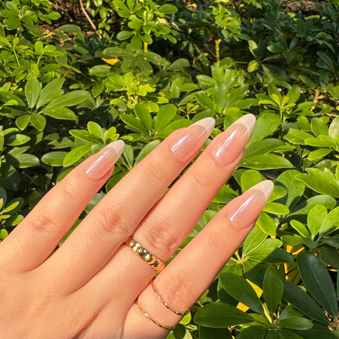 Glossy satin almond-shaped French tips press-on nails in nude pink, offering a delicate and chic finish.