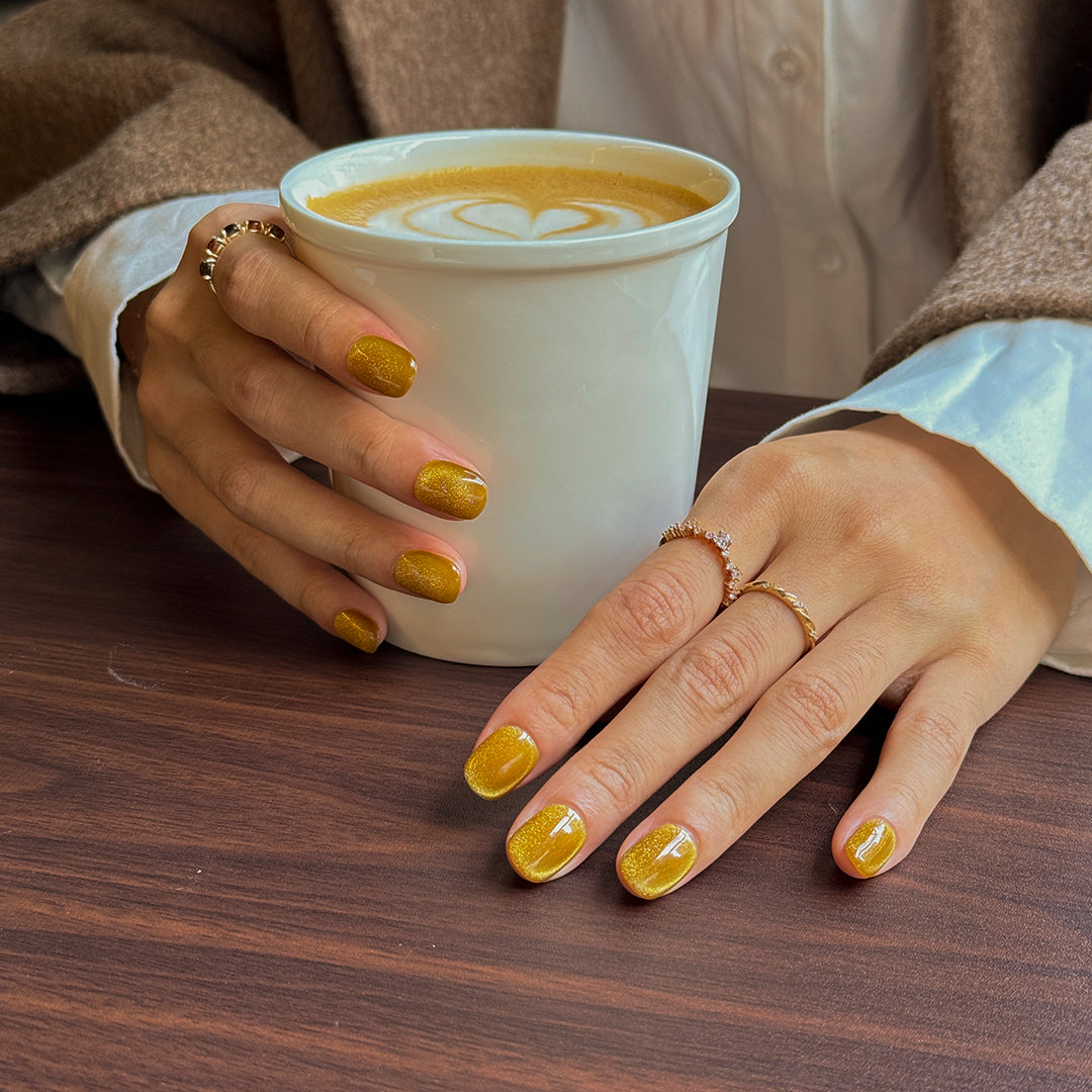 Handmade short glossy cat eye press-on nails in vintage gold with a reflective cat-eye effect.