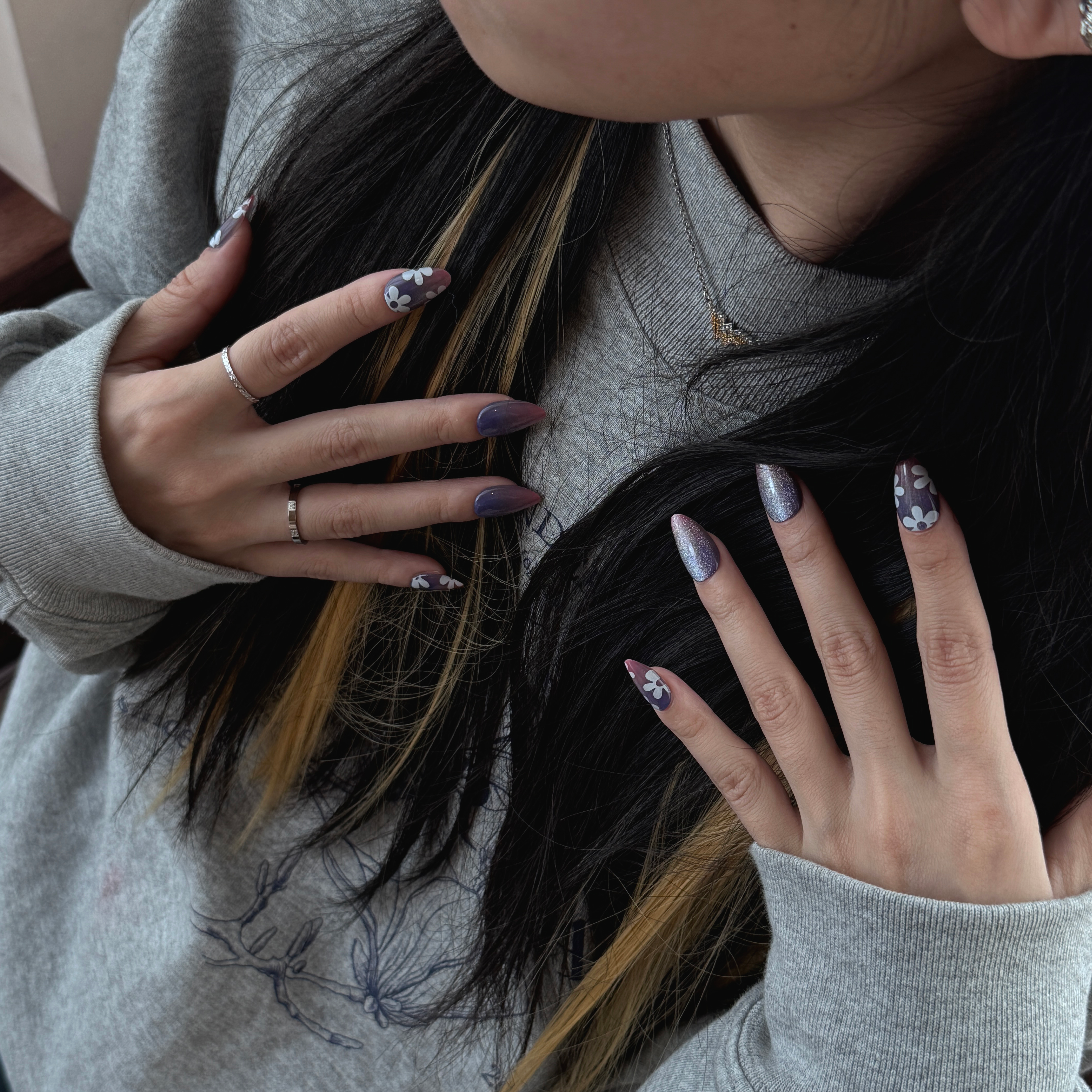 Fincloset dark pink-blue gradient press-on nails with iridescent shimmer, fine glitter, and minimalist white floral accents, ideal for a trendy and edgy spring manicure.
